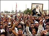 Iraqis hold up an image of Saddam Hussein as they protest his death sentence verdict, in his hometown of Tikrit,